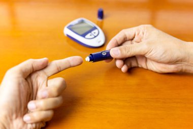 Adam parmak üzerinde mızrak kullanıyor. Kan şekeri seviyesini kontrol ediyor..