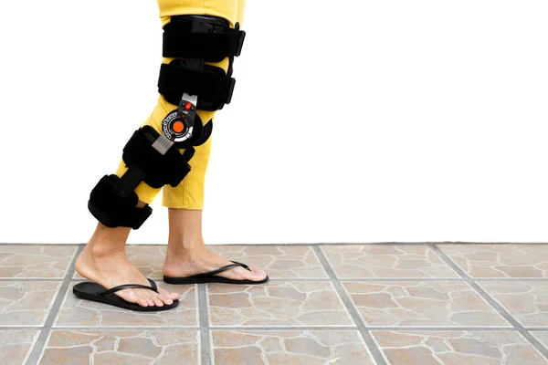 Жінка-нога в ортезі, що стоїть на підлозі ізольовано . — стокове фото