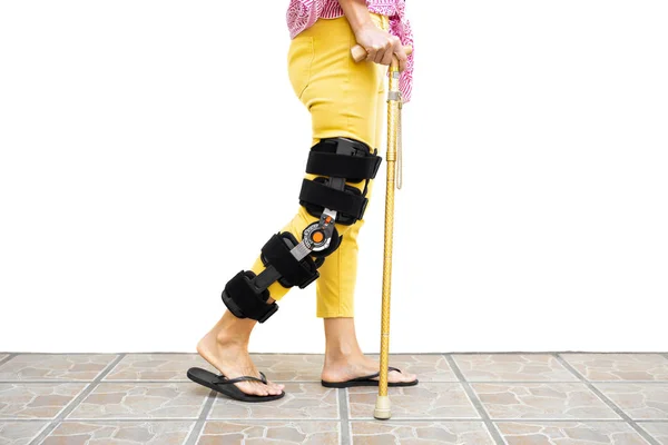 Donna gamba in un'ortesi in piedi sul pavimento isolato . — Foto Stock
