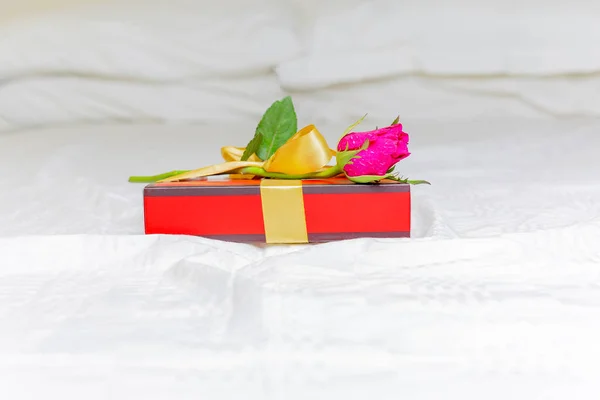 Beautiful pink rose with a gift box on the bed Valentines day concept. — Stock Photo, Image