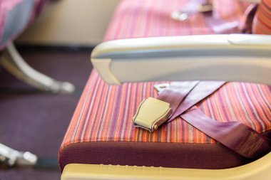 Uçağın yolcu koltuğundaki emniyet kemerleri, seyahat güvenliği kavramı.