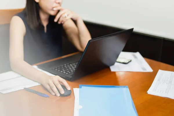 Businesswoman using computer mouse working on laptop with paperwork on table. — Stock Photo, Image