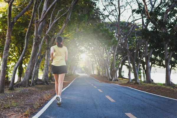 Mujer ejercicio joggint en el parque por la mañana . — Foto de Stock