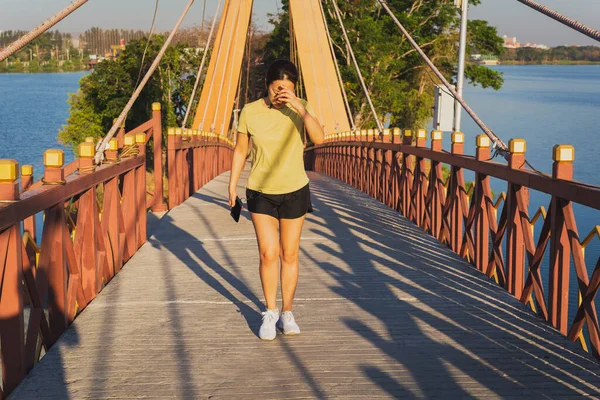 Mujer ejercicio caminar una cruz el puente en verano día soleado . — Foto de Stock