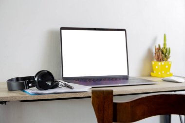 Masada evrak ve kulaklık olan ev konsepti dizüstü bilgisayarından çalış