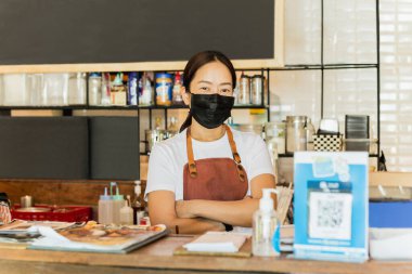 Covid-19 kavramsal tezgahında koruyucu maske takan kadın kafe sahibi.