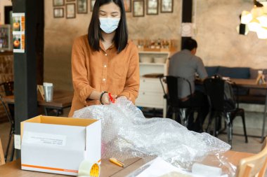 Asyalı kadınlar paket paketleme maskesi takıp internette satıyorlar.