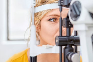 Optometrist, göz hekimliği kliniğinde Slit lambasını inceliyor.