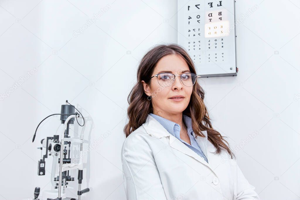 Optometrist standing in front of equipment for eye examination in optical clinic
