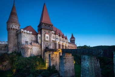 Corvin Castle at twilight, or Hunyadi Castle, one of Seven wonders of Romania. Large, medieval Gothic-Renaissance building. Hunedoara, Romania clipart