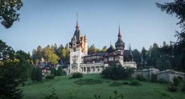 Peles Kalesi, Romanya 'nın Sinaia kentinde Kral I. Charles' ın ünlü konutu. Kraliyet sarayının ve parkın gündoğumunda yaz manzarası.