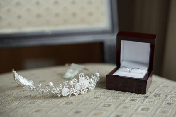 Anillos de boda en una caja marrón y una tiara nupcial —  Fotos de Stock