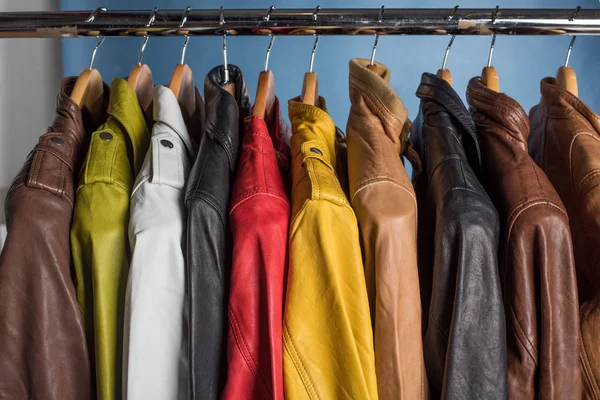 Raf üzerinde mavi arka plan asılı farklı renk deri ceket