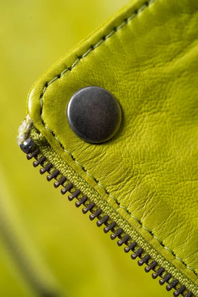 Metal button on green color leather jacket. Lime color