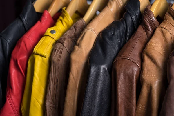 Farklı renk deri ceket raf beyaz arka plan üzerinde asılı