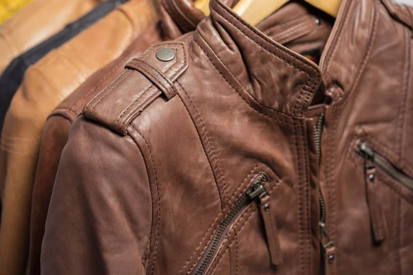 Farklı renk deri ceket raf beyaz arka plan üzerinde asılı