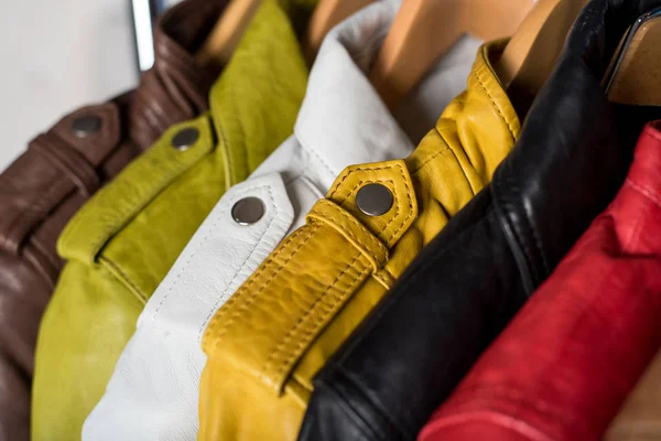 Raf üzerinde mavi arka plan asılı farklı renk deri ceket