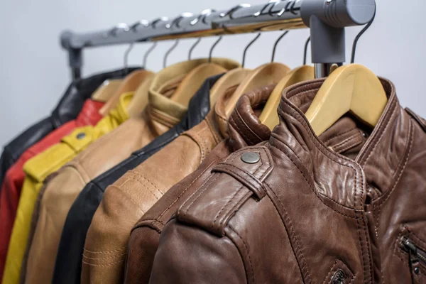 Farklı renk deri ceket raf beyaz arka plan üzerinde asılı