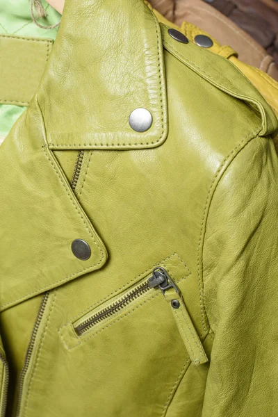 Muitos jaqueta de couro colorido pendurado no rack no fundo azul — Fotografia de Stock