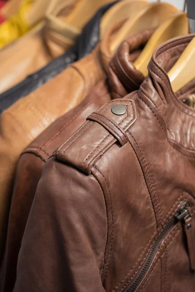 Farklı renk deri ceket raf beyaz arka plan üzerinde asılı