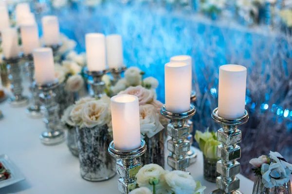 Decoração de casamento. Velas em candelabro e rosas. Fundo azul — Fotografia de Stock