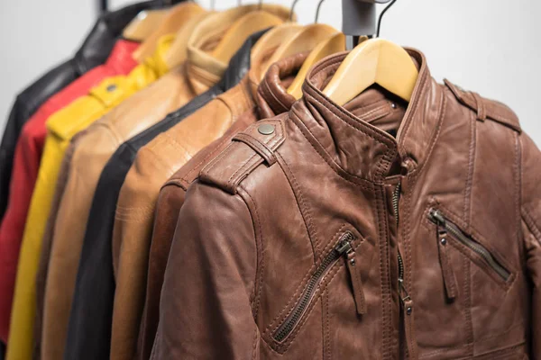 Farklı renk deri ceket raf beyaz arka plan üzerinde asılı
