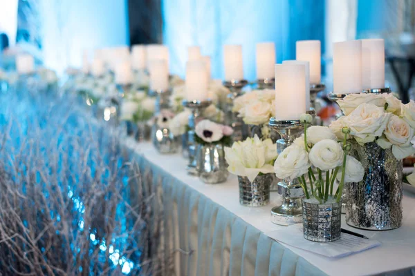 Decoração de casamento. Velas em candelabro e rosas. Fundo azul — Fotografia de Stock