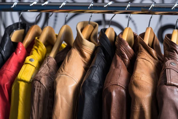 Farklı renk deri ceket raf beyaz arka plan üzerinde asılı