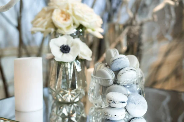 Macaroons masada bir vazoda güller ve mum ile dekore edilmiş 