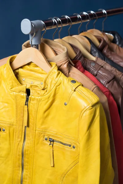 Raf üzerinde mavi arka plan asılı farklı renk deri ceket