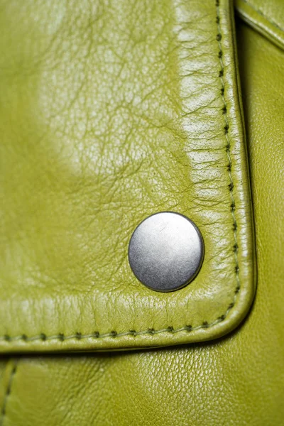 Botón de metal en chaqueta de cuero de color verde. Color lima. Detalle chaqueta de cuero Macro. Botón de cierre —  Fotos de Stock