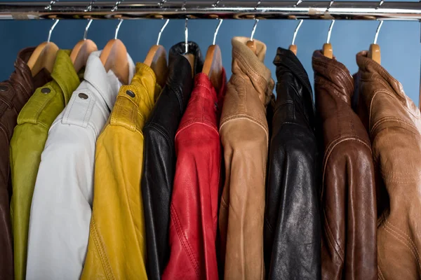 Raf üzerinde mavi arka plan asılı farklı renk deri ceket
