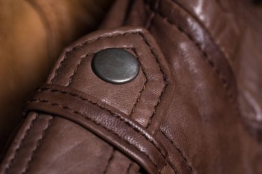 Kahverengi deri ceket omuz metal toka düğme. Makro deri omuz detayı