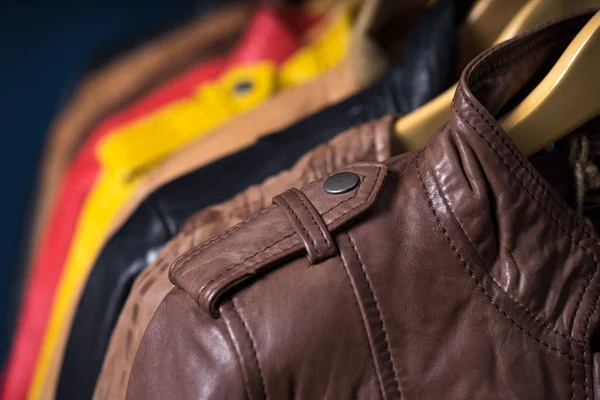 Raf üzerinde mavi arka plan asılı farklı renk deri ceket