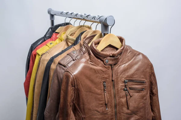 Farklı renk deri ceket raf beyaz arka plan üzerinde asılı