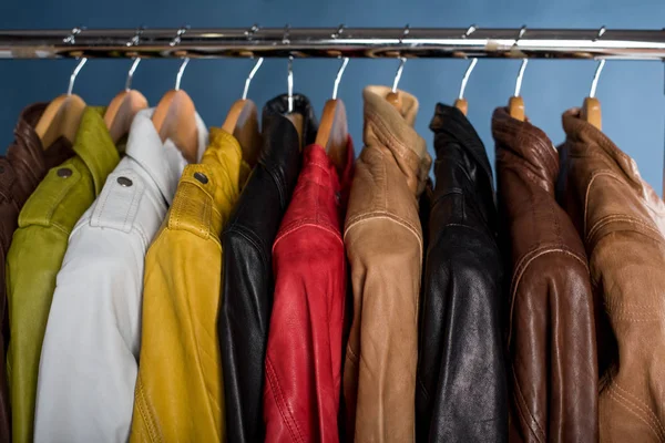 Raf üzerinde mavi arka plan asılı farklı renk deri ceket