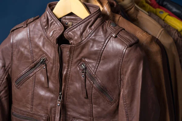 Raf üzerinde mavi arka plan asılı farklı renk deri ceket