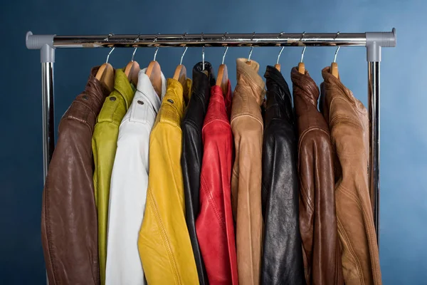 Raf üzerinde mavi arka plan asılı farklı renk deri ceket
