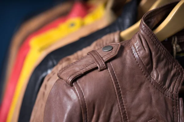 Raf üzerinde mavi arka plan asılı farklı renk deri ceket