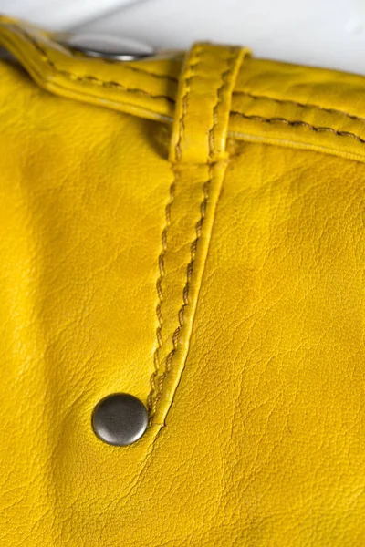 Botão de fecho de metal na jaqueta amarela de couro. detalhe do ombro jaqueta de couro. Detalhe de couro macro — Fotografia de Stock