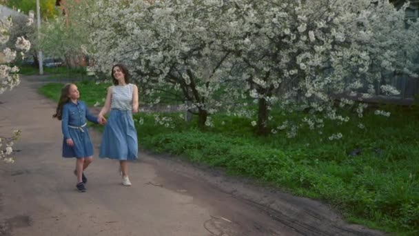 Madre con su linda hijita corriendo por la calle cogida de la mano — Vídeos de Stock