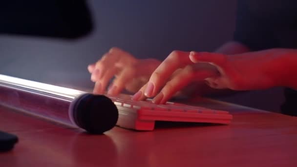 指尖贴在键盘上 黑客女孩在电脑上工作 红色的霓虹灯照亮了她的手 后续行动 — 图库视频影像