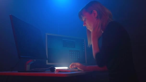 黑客帝国的白发女人正在电脑上工作 而浓烟在地下的办公室里四处蔓延 房间里充满了蓝色的霓虹灯 数字电阻 — 图库视频影像
