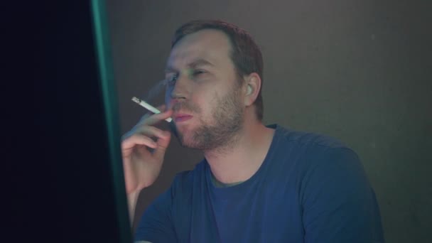 电脑黑客正在黑暗的办公室吸烟和在电脑上工作 特写特写 微笑的黑客在监视器中显示中指 数字电阻 — 图库视频影像