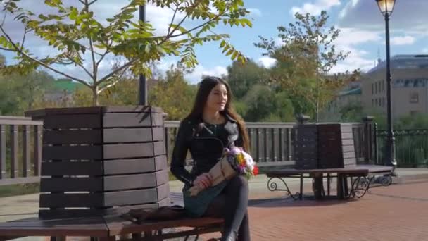 Menina Com Buquê Flores Está Sentado Banco Madeira Sob Árvore — Vídeo de Stock