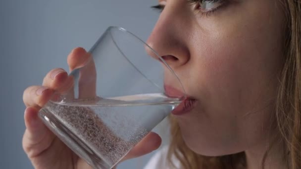 近距离观察妇女饮用闪闪发光的水 溶化的药物 — 图库视频影像