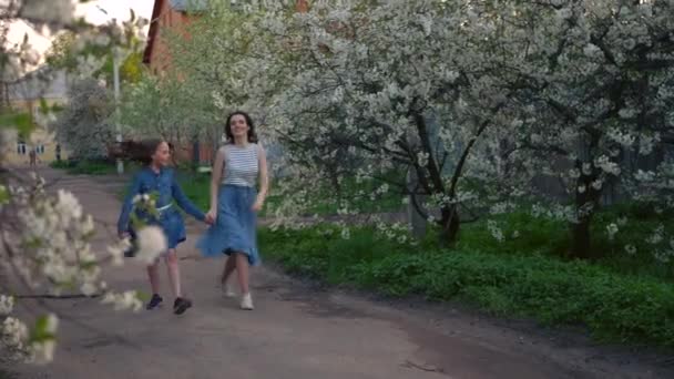 Mama i jej córka bawią się w kotka i myszkę w parku, matka i dziewczyna uciekają. — Wideo stockowe