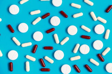 Mavi arka planda yatan hap ve tabletlerin olduğu daireyi kapat.. 