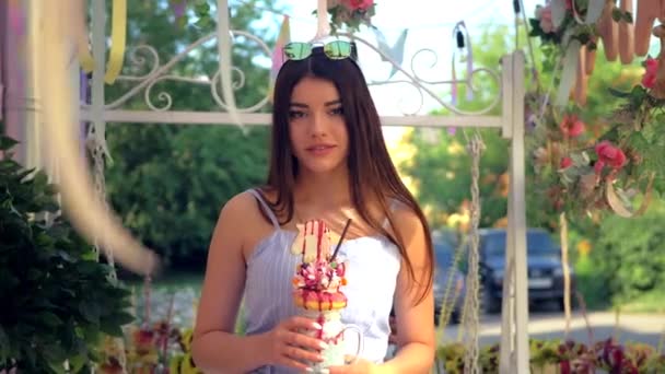 Elinde Çok Katmanlı Milkshake Olan Mavi Elbiseli Büyüleyici Beyaz Kadın — Stok video