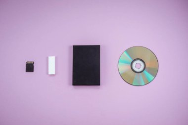 Leylak arkaplanındaki veri depolama cihazlarının geçmişi. dvd, flash disk, hard disk, sd kart üst görünümü